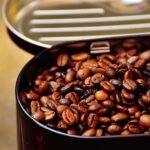 Close-up of roasted coffee beans in an open metal container, highlighting texture.