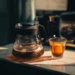A glass coffee server carafe filled with brewed coffee and a matching glass cup, illustrating top carafe options.