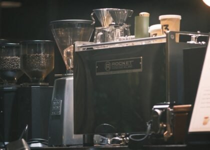 Close-up of an espresso machine in a cafe with coffee grinders and cups.