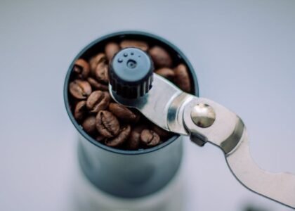 Close-up of a manual burr grinder filled with coffee beans, illustrating parts to check when finding replacement components.
