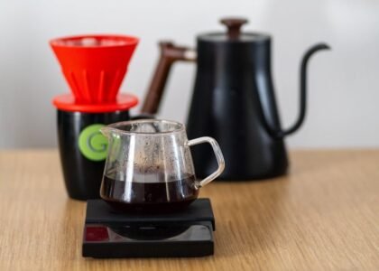 Close-up of a V60 coffee setup with dripper, scale, and kettle, highlighting specialty coffee brewing.