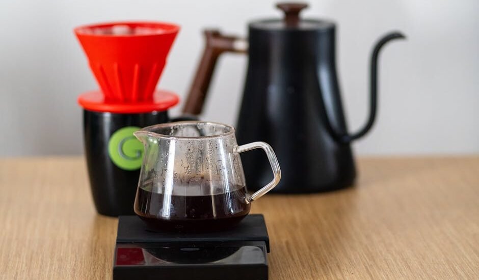 Close-up of a V60 coffee setup with dripper, scale, and kettle, highlighting specialty coffee brewing.