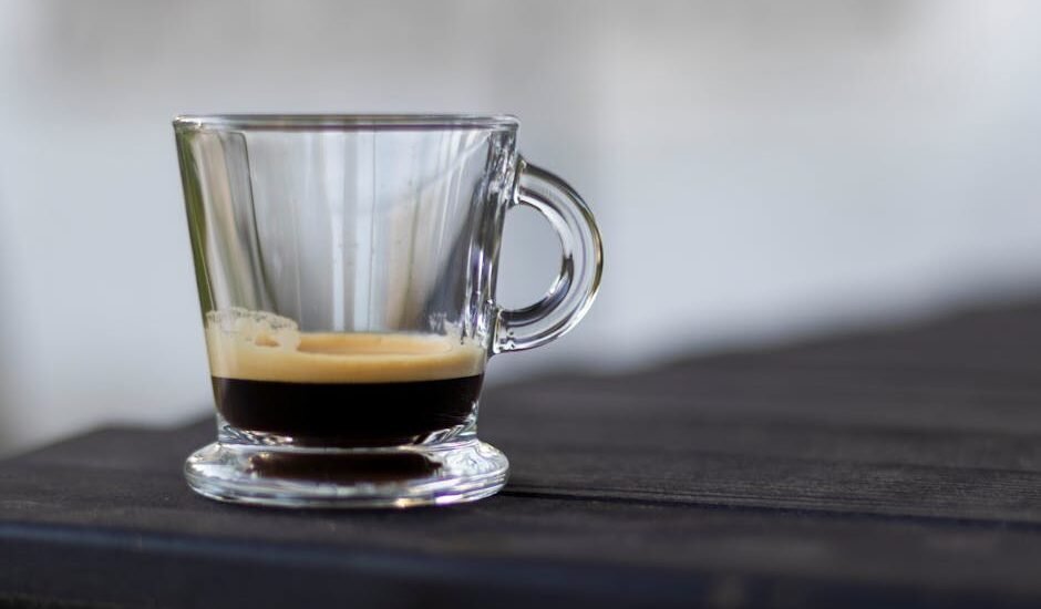 A clear glass cup of espresso with a visible layer of crema, illustrating the science behind espresso foam.