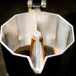 Detailed view of coffee brewing inside a classic moka pot. Perfect for caffeine lovers.