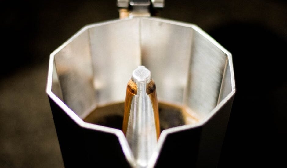 Detailed view of coffee brewing inside a classic moka pot. Perfect for caffeine lovers.