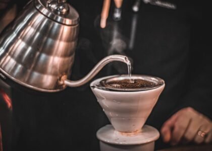 A gooseneck electric kettle pours hot water over coffee grounds in a dripper, illustrating top kettle choices for home brewers.