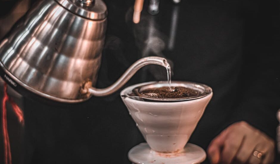 A gooseneck electric kettle pours hot water over coffee grounds in a dripper, illustrating top kettle choices for home brewers.