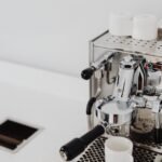 A dual boiler espresso machine with portafilter and cups, relevant to espresso brewing.