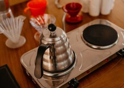A stainless steel electric kettle on a brewing station, showcasing pour-over coffee gear.