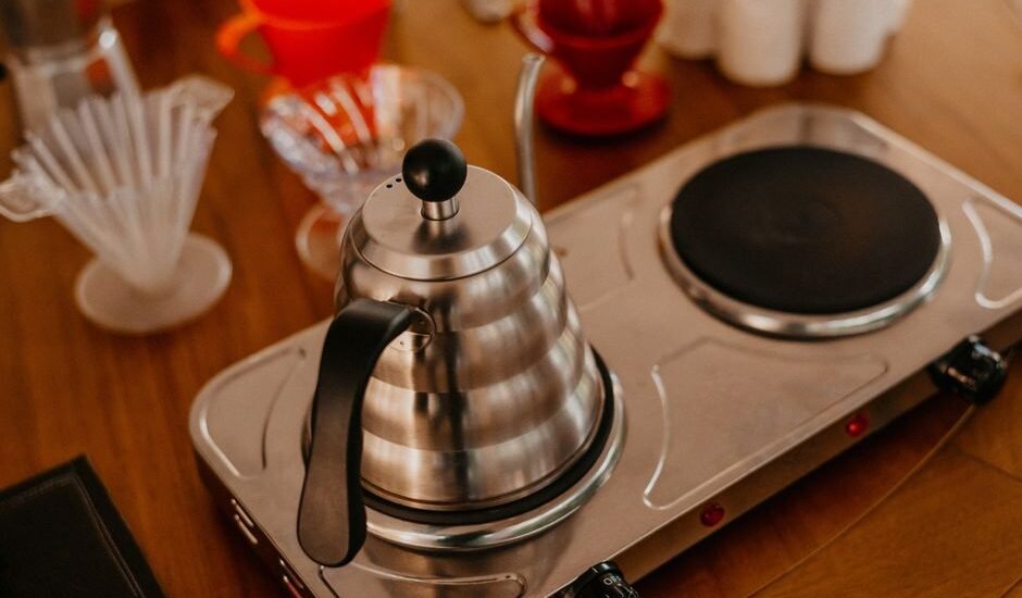 A stainless steel electric kettle on a brewing station, showcasing pour-over coffee gear.