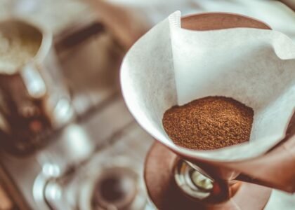 A cone coffee dripper filled with ground coffee, relevant to using basket filters.