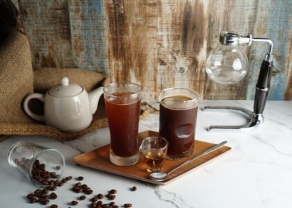 Cold brew maker setup featuring two glasses of cold brew coffee and coffee beans.