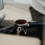 A regular portafilter filled with ground coffee, illustrating the difference between portafilter types.