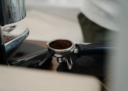A regular portafilter filled with ground coffee, illustrating the difference between portafilter types.