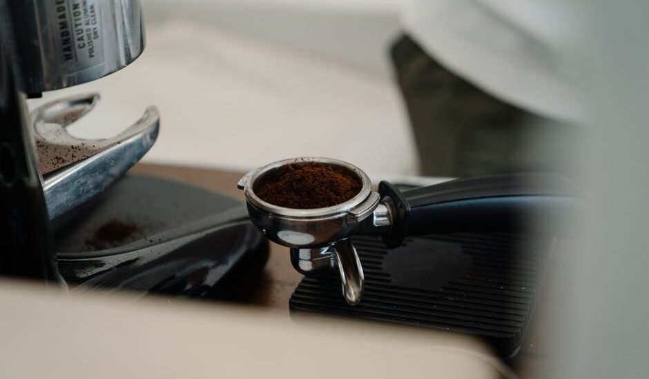 A regular portafilter filled with ground coffee, illustrating the difference between portafilter types.
