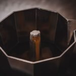 Electric moka pot brewing coffee, illustrating features for reviews.