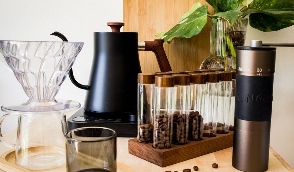 Espresso distribution tool alongside coffee beans and brewing equipment for moka pots.