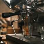 Espresso machine extracting coffee into a glass, illustrating pre-infusion process.