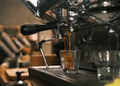 Espresso machine extracting coffee into a glass, illustrating pre-infusion process.
