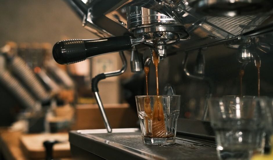 Espresso machine extracting coffee into a glass, illustrating pre-infusion process.