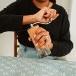 A person adjusting a manual coffee grinder, illustrating how to reset it.