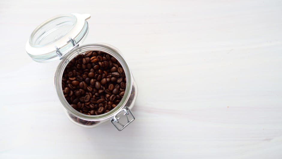A glass jar filled with fresh coffee beans, illustrating how to store coffee.
