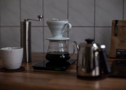 A coffee brewing setup showing a pour-over dripper, scale, and kettle, illustrating coffee-to-water ratio.