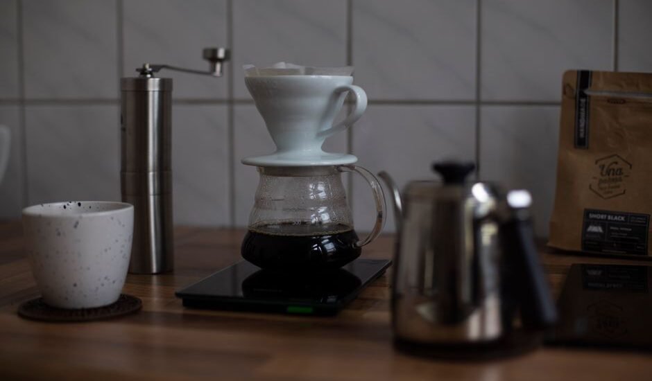 A coffee brewing setup showing a pour-over dripper, scale, and kettle, illustrating coffee-to-water ratio.