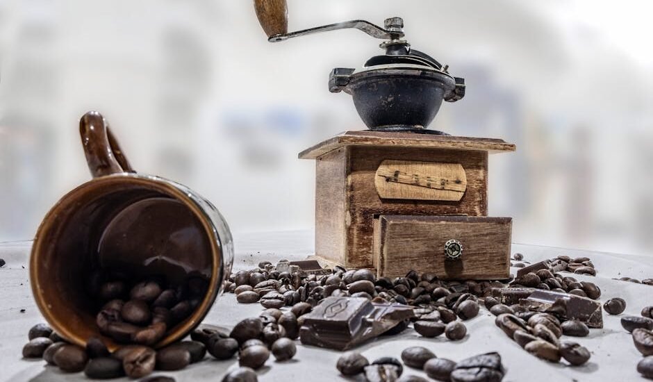 A burr coffee grinder, coffee beans, and a mug, illustrating the article on burr grinders.