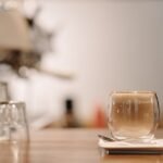 A clear double wall cup filled with coffee, illustrating the difference in cup design.