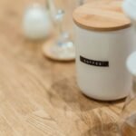 A vacuum coffee canister labeled 'coffee' on a wooden table, relevant to coffee storage.
