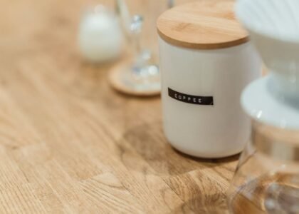 A vacuum coffee canister labeled 'coffee' on a wooden table, relevant to coffee storage.