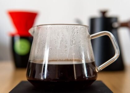 A glass thermal carafe filled with brewed coffee, showcasing its design and function.