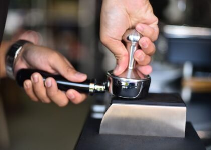 A person tamping espresso grounds in a portafilter, illustrating the tamping process.