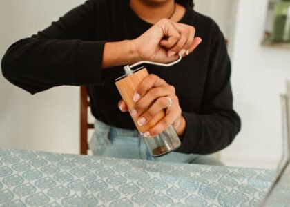 A person grinding coffee beans with a manual grinder, relevant to best manual coffee grinders for espresso.