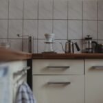 A coffee brewing setup featuring a pour-over dripper, kettle, and French press, relevant to cleaning tablets for grinders.