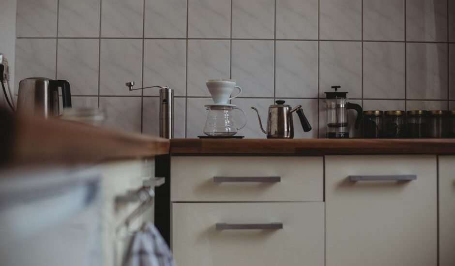A coffee brewing setup featuring a pour-over dripper, kettle, and French press, relevant to cleaning tablets for grinders.