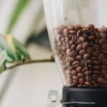 A clear hopper filled with roasted coffee beans, relevant to storage advice.