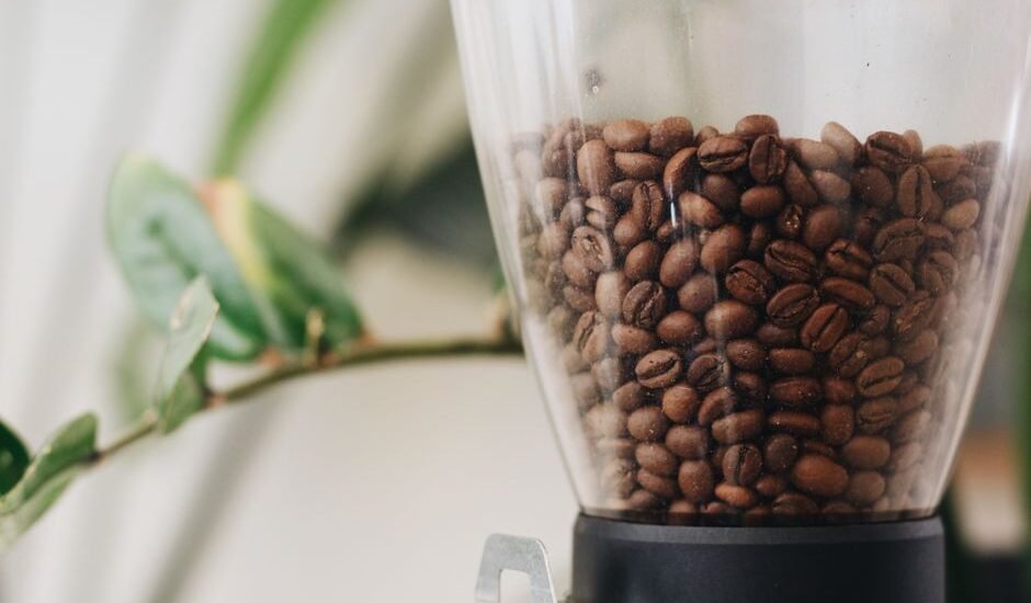 A clear hopper filled with roasted coffee beans, relevant to storage advice.